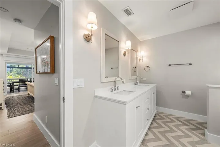 Full bathroom with double vanity and baseboards