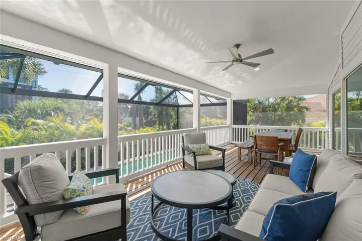Sunroom / solarium with outdoor furniture, vaulted ceiling, a ceiling fan, and healthy amount of natural light