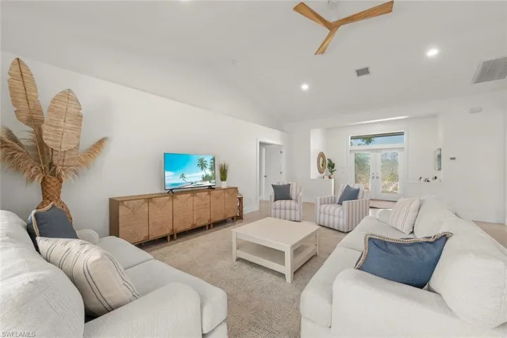 Living room with french doors, vaulted ceiling, recessed lighting, and a ceiling fan