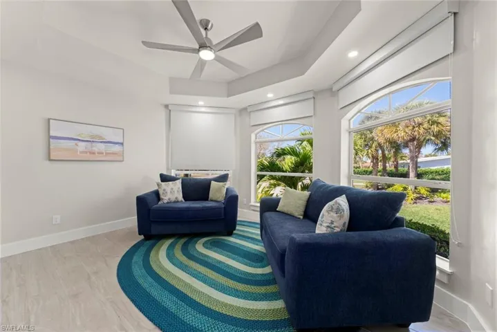 Sitting room featuring a raised ceiling, ceiling fan, light wood-type flooring, and recessed lighting