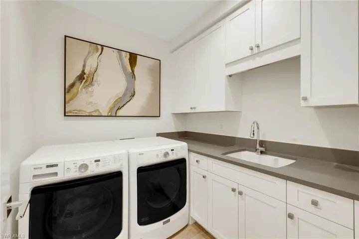 Laundry room with sink and additional storage space and a laundry tub.