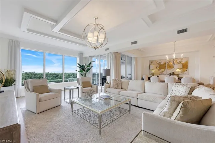 Living room features a gorgeous ceiling detail, wood flooring and a spectacular golf course AND bay views.