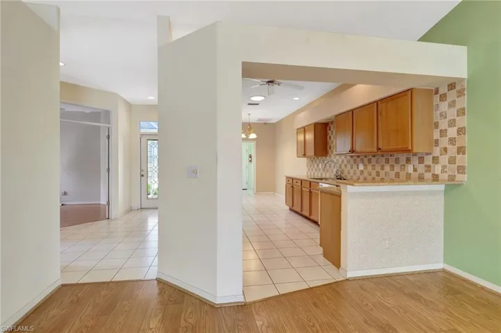 Kitchen with light wood finished floors, light countertops, a sink, and tasteful backsplash