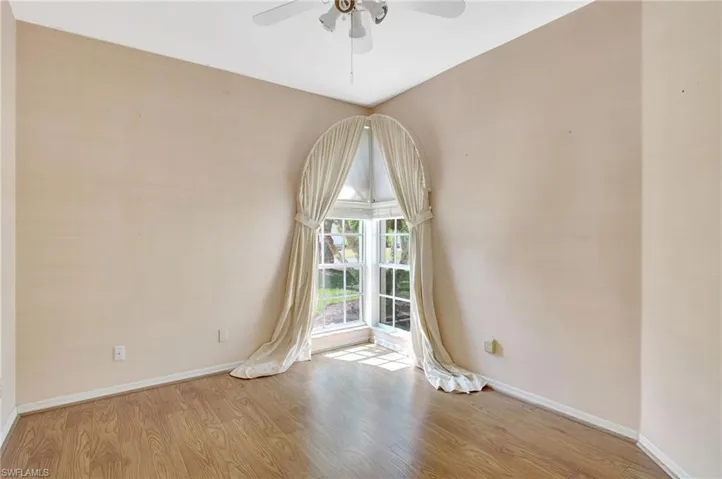 Unfurnished room with baseboards, wood finished floors, and ceiling fan
