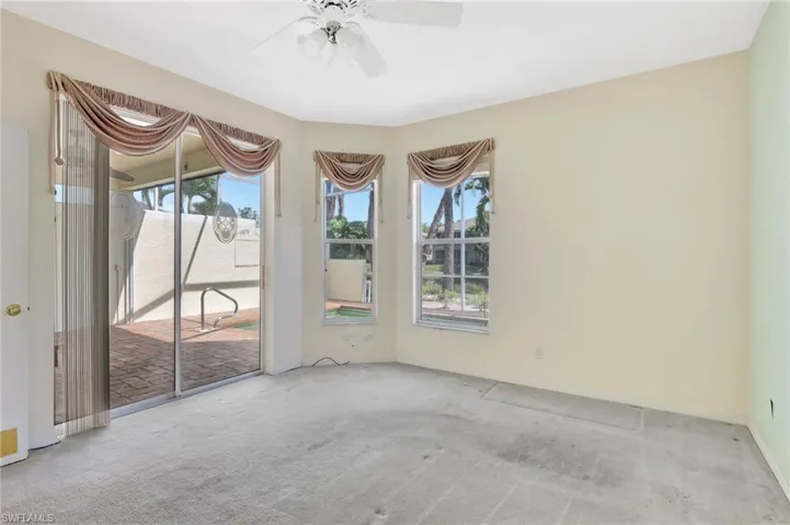 Empty room featuring a ceiling fan and carpet