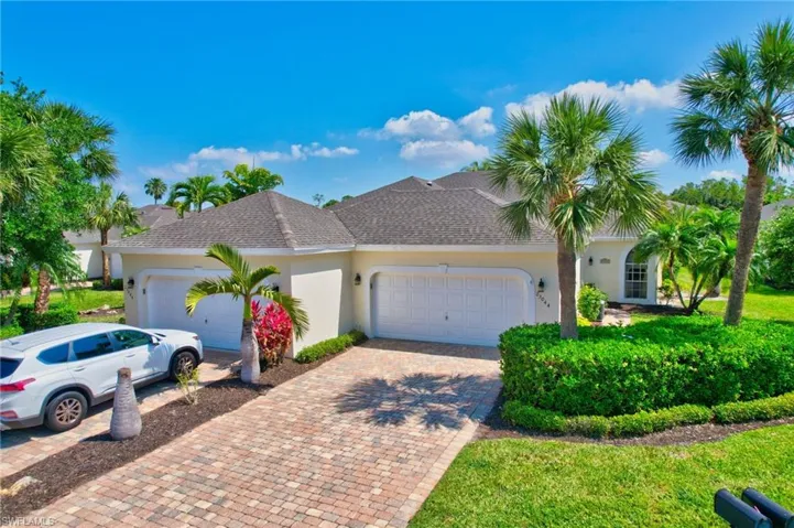View of front of property with stucco siding, an attached garage, roof with shingles, and decorative driveway
