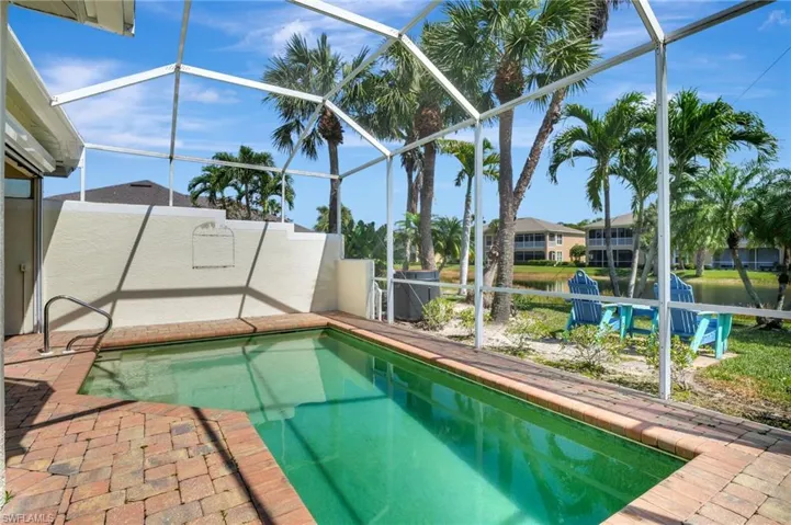 Outdoor pool featuring glass enclosure and a patio