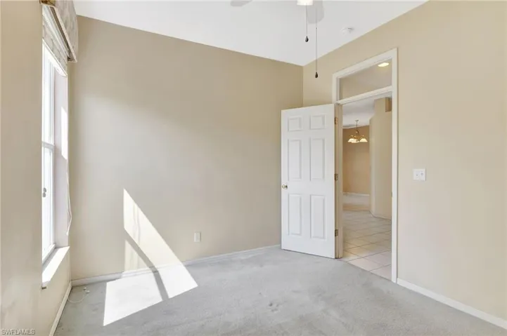 Spare room with baseboards, light colored carpet, and ceiling fan