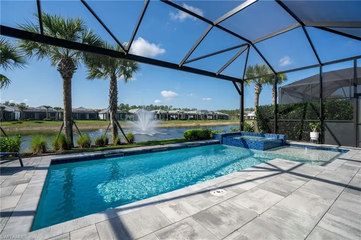 Integrated pool / spa featuring a sunroom, a residential view, a lanai, a water view, and a patio