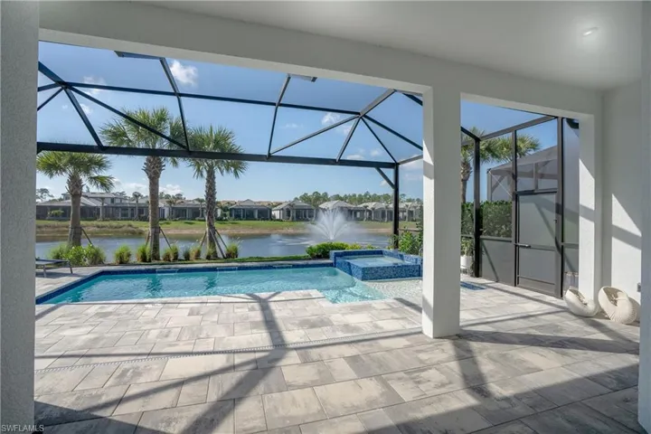 Combined pool / hot tub featuring a sunroom, a residential view, a lanai, and a patio area