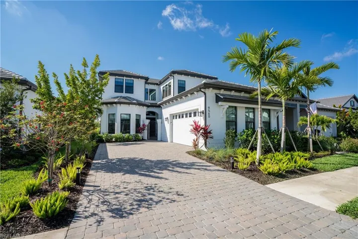 View of front of property with decorative driveway, stucco siding, and a garage