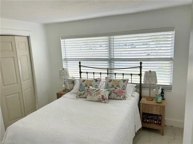 Bedroom with a closet, a textured ceiling, and tile patterned floors