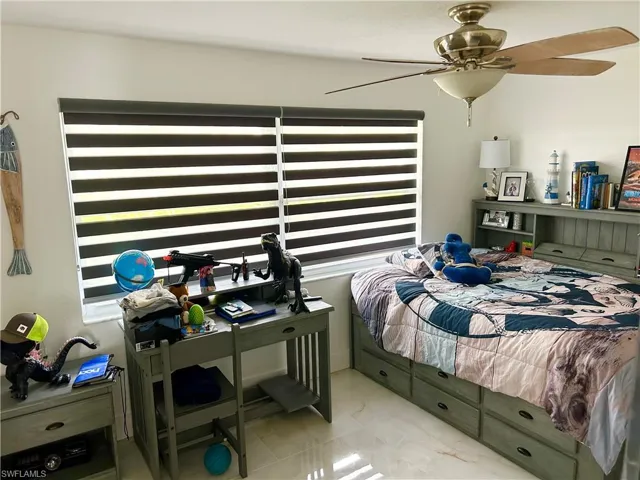 Bedroom featuring ceiling fan and multiple windows