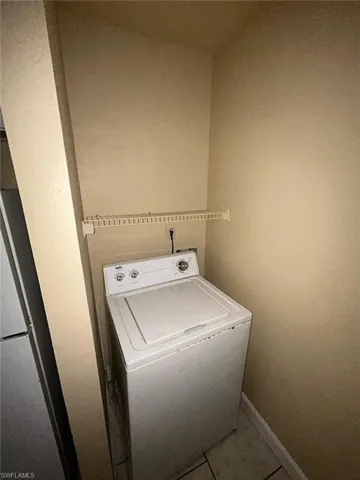 Laundry room with washer / clothes dryer and tile patterned flooring