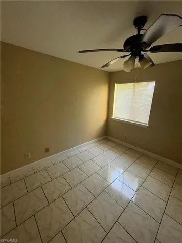 Spare room with a ceiling fan and light tile patterned floors