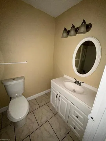 Half bathroom with vanity and tile patterned flooring