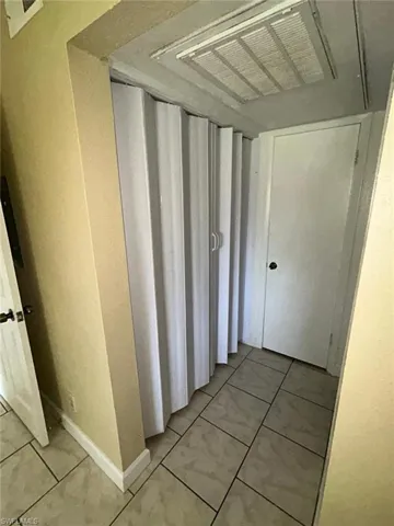 Corridor with light tile patterned floors and baseboards