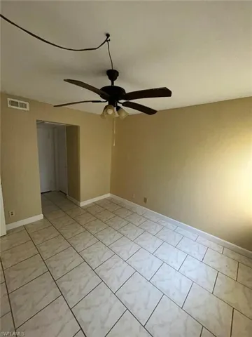 Unfurnished room with ceiling fan and light tile patterned floors
