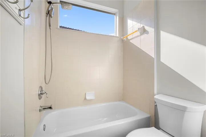 Bathroom with toilet and bathing tub / shower combination