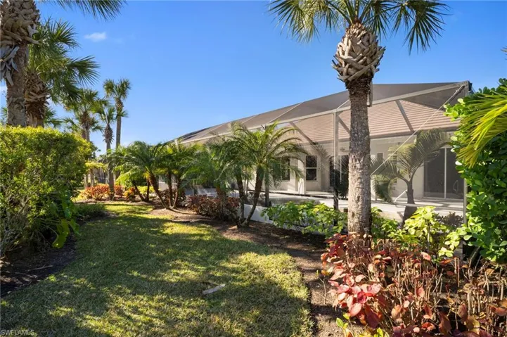 View of grassy yard featuring a sunroom and a lanai