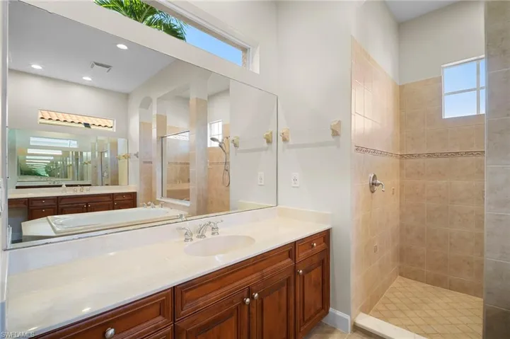 Full bath featuring walk in shower, healthy amount of natural light, and vanity