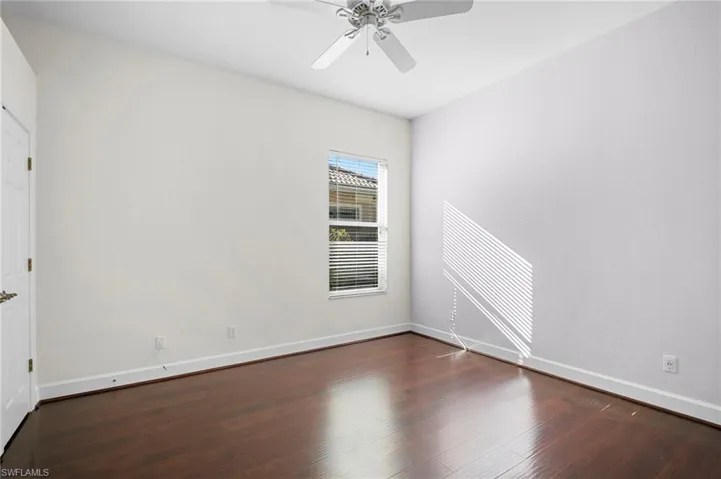 Spare room featuring dark wood finished floors and a ceiling fan