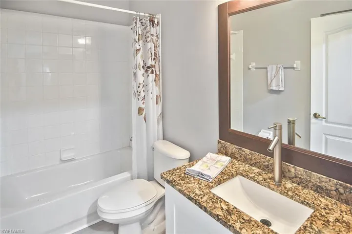 Bathroom featuring vanity and shower / bath combo with shower curtain