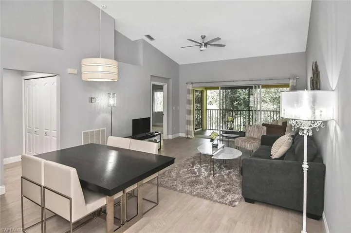 Living room featuring a ceiling fan, wood finished floors, and high vaulted ceiling