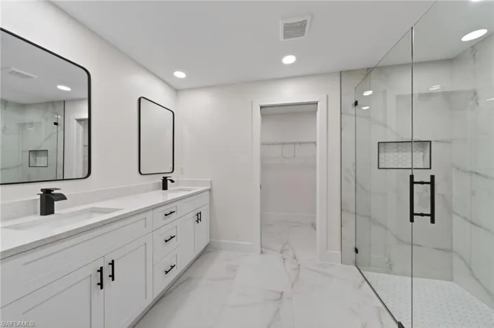 White double vanity with integrated sinks, quartz countertops, and matte black fixtures