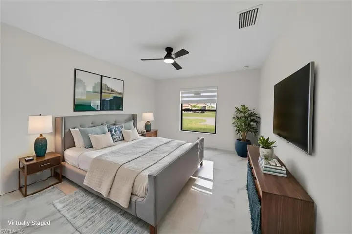 Spacious room featuring light-toned walls, white tile flooring, and a ceiling fan with integrated lighting