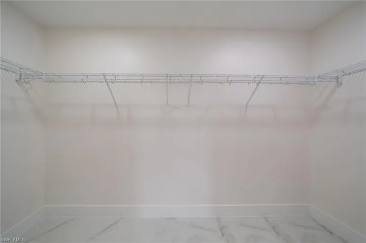 Spacious closet with wire shelving system and light-toned tile flooring