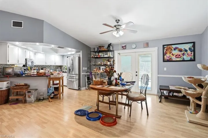 Dining room with french doors, lofted ceiling, light wood-type flooring, and ceiling fan