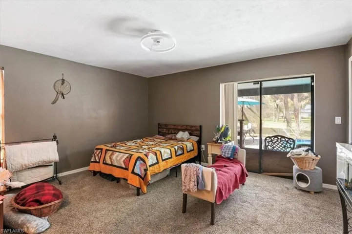 Carpeted bedroom with access to exterior and baseboards