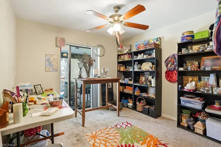 Home office with light carpet and a ceiling fan