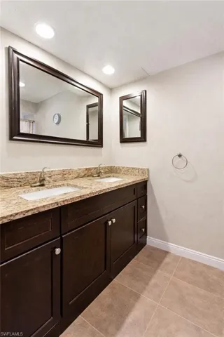 VIRTUALLY STAGED. Full bath featuring double vanity and light tile patterned floors