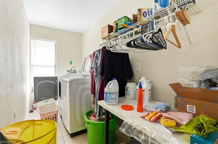 Laundry area featuring independent washer and dryer and light tile patterned floors
