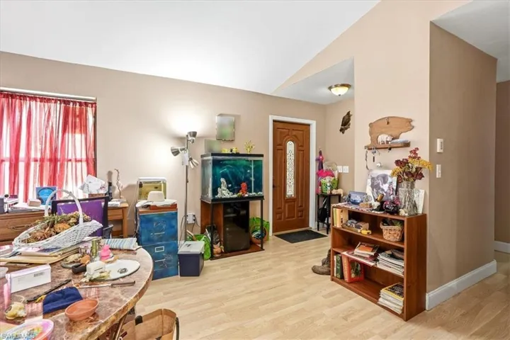 Entryway with light wood-type flooring and lofted ceiling