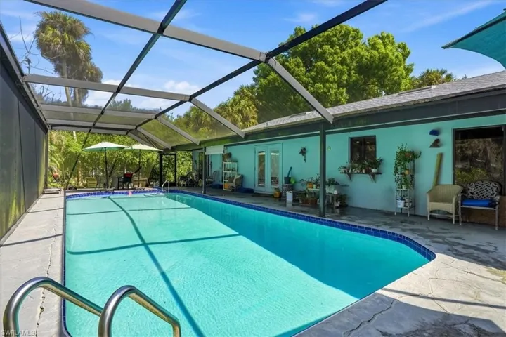 Outdoor pool featuring a patio, a sunroom, a lanai, and french doors