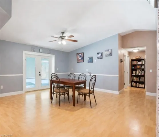 VIRTUALLY STAGED. Dining space featuring vaulted ceiling, a ceiling fan, light wood-style floors, and french doors