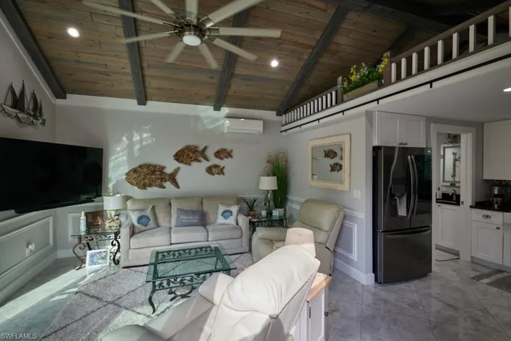Living room with wood ceiling, ceiling fan, beamed ceiling, and high vaulted ceiling