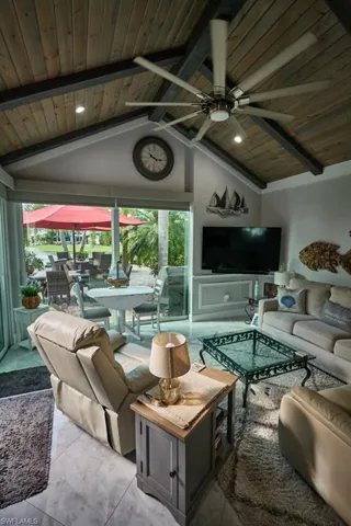 Living room with vaulted ceiling with beams, wooden ceiling, and a healthy amount of sunlight