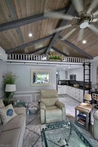 Living room featuring ceiling fan, wood ceiling, and lofted ceiling with beams