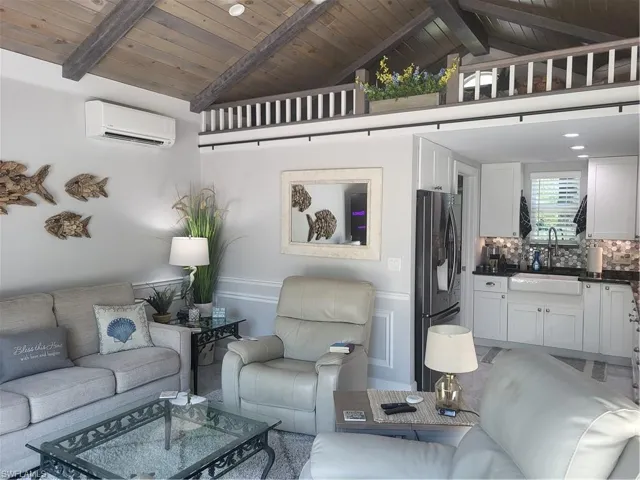 Living room featuring beamed ceiling, sink, wooden ceiling, and a wall mounted AC