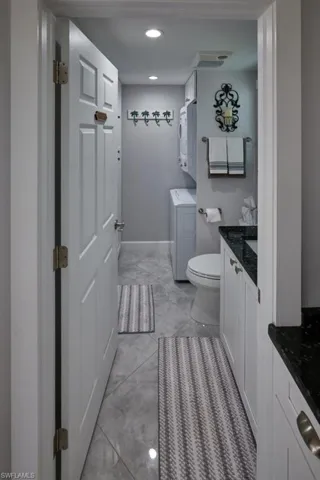 Bathroom with washer / dryer, vanity, and toilet