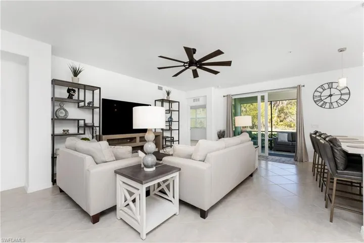 Living room with a ceiling fan and light tile patterned floors
