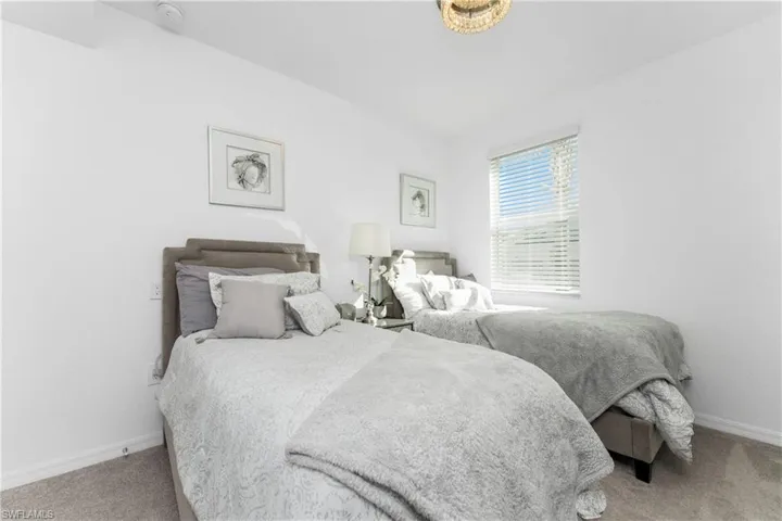 Bedroom with baseboards and light colored carpet