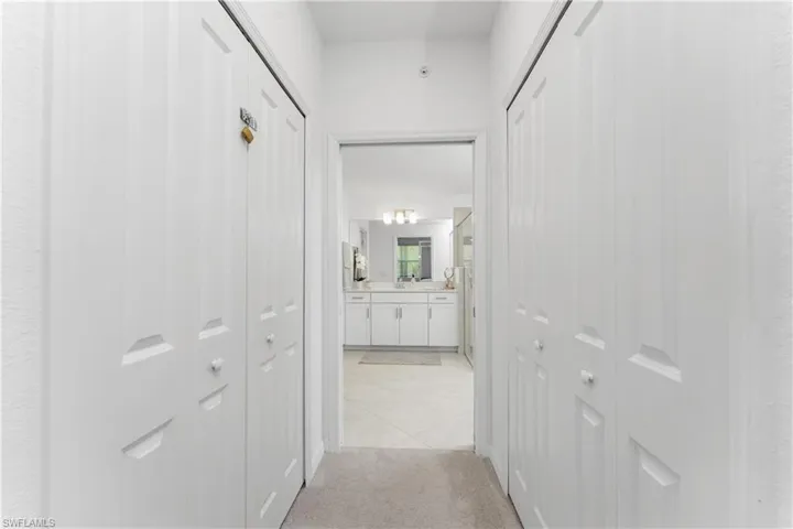 Hall featuring light colored carpet