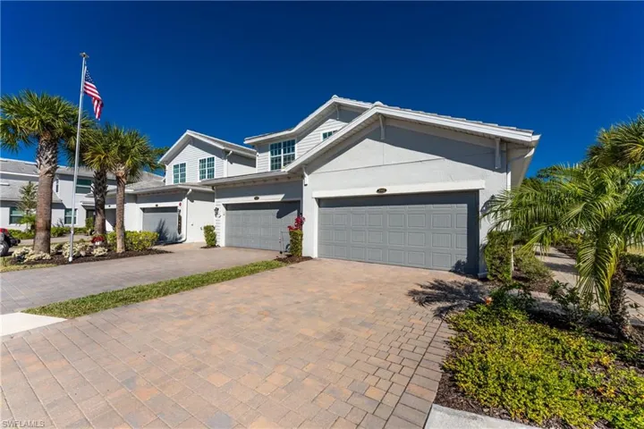View of front of house with decorative driveway, stucco siding, and a garage