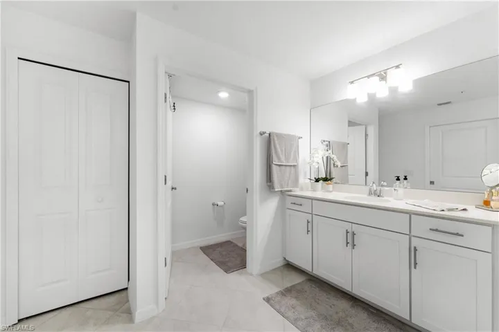 Full bathroom featuring a closet, vanity, and light tile patterned floors