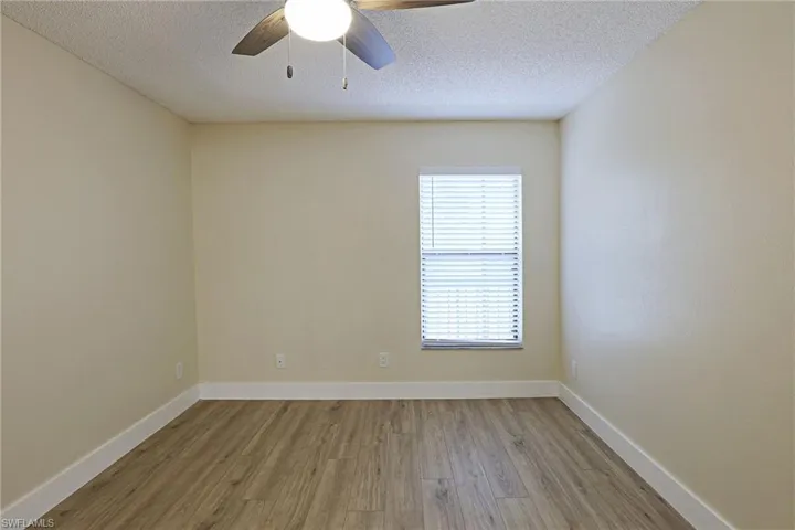 Spare room featuring wood finished floors, a textured ceiling, and a ceiling fan